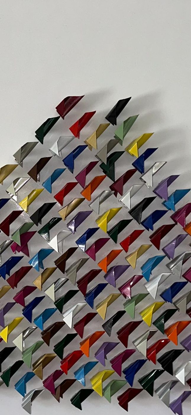 Dettaglio ravvicinato: triangoli multicolore piegati con le loro ombre
